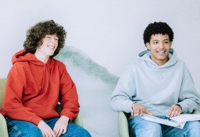 two teen boys smiling in group therapy setting